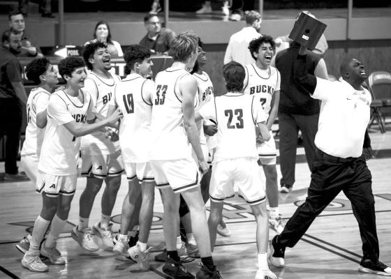 The Alpine Fightin’ Bucks and Coach Aaron Hardwick celebrate their bi-district win against the Denver City Mustangs. Photo by Annika Canaba