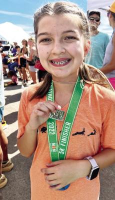 Alpine Middle School eighth grade student Isla Velasco competed in last weekend’s Marathon to Marathon 5k, and won the women’s division with a time of 24:31. Here she shows off her winning buckle. Photo by Jessica Velasco