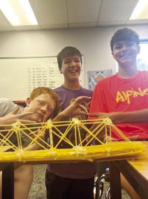 Ty Ritchie, Davis Edwards, and Brody Warren pose in front of the spaghetti bridge they built and designed during their STEAM class. Courtesy photo