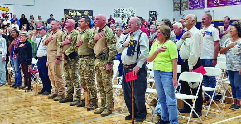 Alpine ISD honored local veterans on Monday with a program full of song, poetry, and proclamation. Alpine veterans are pictured honoring the U.S. flag during the National Anthem. Photo by Kara Gerbert