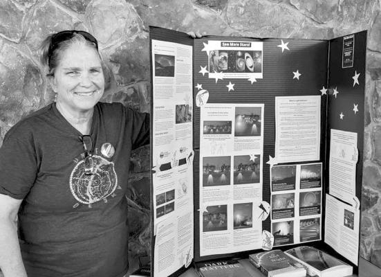 Laura Gold of West Texas Friends of the Night Sky is excited to share information promoting dark skies awareness as she pauses for a photo next to her starry poster at Alpine Public Library’s See More Stars! event held on Aug 12. The event was presented by McDonald Observatory, Big Bend Conservation Alliance, Marathon Dark Sky Park, and the Alpine Night Sky Team. Avalanche photo by Roxanne Hill