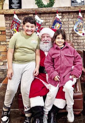 Marathon’s Fiesta de Noche Buena that was held this past Saturday had a visit from Santa, who set up inside Trans Pecos Banks to visit with kids like Caius and Luna Gonzales and ask them what items were on this year’s Christmas list. Photo by Kara Gerbert