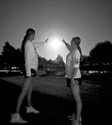 AHS Cross-Country runners Elizabeth Marta and Trinity Vega try and ‘capture the moon’ during the Moonlit Miles fundraiser held on August 18 for the Alpine Cross Country teams at Kokernot Park. Courtesy photo