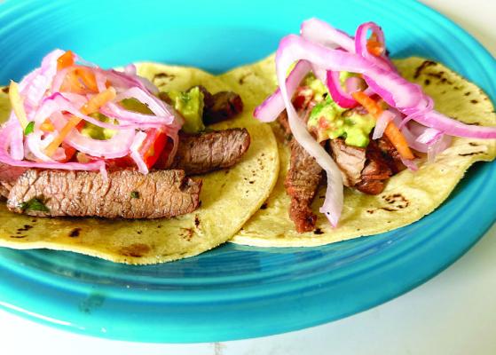 Carne asada fajitas on corn tortillas with pickled red onions and guacamole. Photo by J.T. Maroney