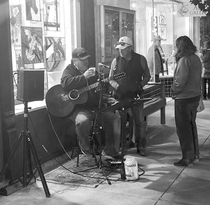 Rick Ruiz and Tony Lujan chat with a music fan and enjoy a cup of wassail during this past Friday evening’s Wassail Crawl in downtown Alpine. Photo by Joh Covington