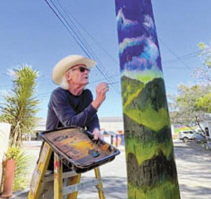 Artist Kerry Awn Fitzgerald paints a utility pole for the Alpine Alley Arts project. Courtesy photo