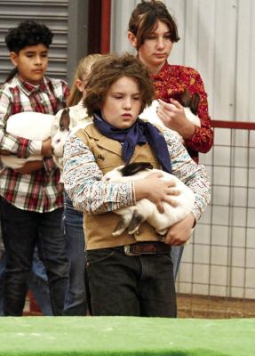 FortDavis’VirgilClarkexhibitsaseriousexpressionashe heads to the show table with his 8 lb. 3.9oz stewer rabbit. Photo by Felipe Fierro