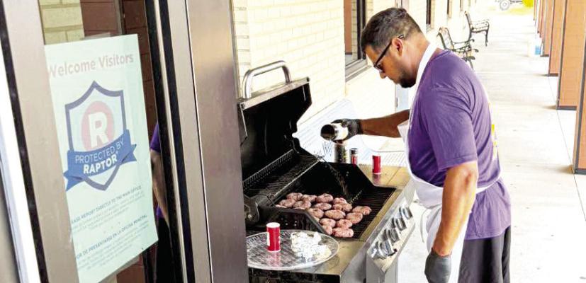 Alpine High School Coach Adam Llanez worked the grill last week during the new teacher orientation held at AHS. He grilled up sliders and hot dogs for the new additions to Alpine ISD. Courtesy photo