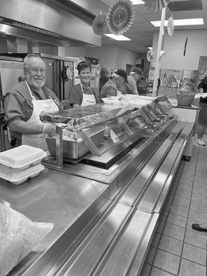 Matt Walter and Judy Stokes smile as they serve a delicious spaghetti meal last Thursday at the Alpine Elementary School cafeteria. Each year, the Kiwanis Club of Alpine serves this meal, with all proceeds going back into the community.
