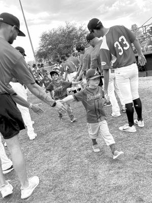 Alpine’s Braves come through the Alpine Cowboy’s welcome line during opening day ceremonies at Alpine’s Kokernot Field. Courtesy photo