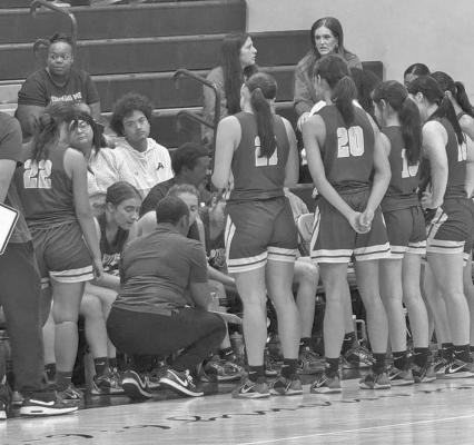 Coach Taryn Johnson goes over strategy with the Lady Bucks varsity basketball team during tournament play in Lubbock Courtesy photo