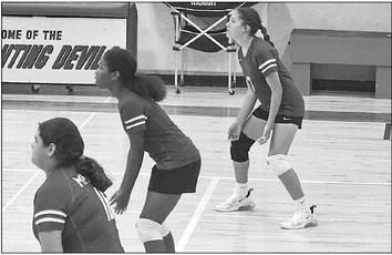 The Lady Horns volleyball players stand in readiness to break serve in a recent game. Courtesy photo