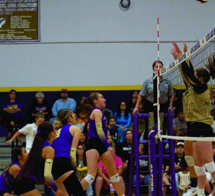 Lady Bucks Evelyn Smith, Peyton Kinkade, and Naida Morris worked to grit it out at the net against the Lady Mustangs of Andrews last week. Photo by Kara Gerbert