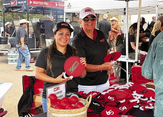 Valeria Torres and Evelyn Rakun pass out fans at Big Bend Telephone’s afternoon BBQ and tailgate party held last Friday afternoon as part of Viva Big Bend. Photo by Abigail Scott