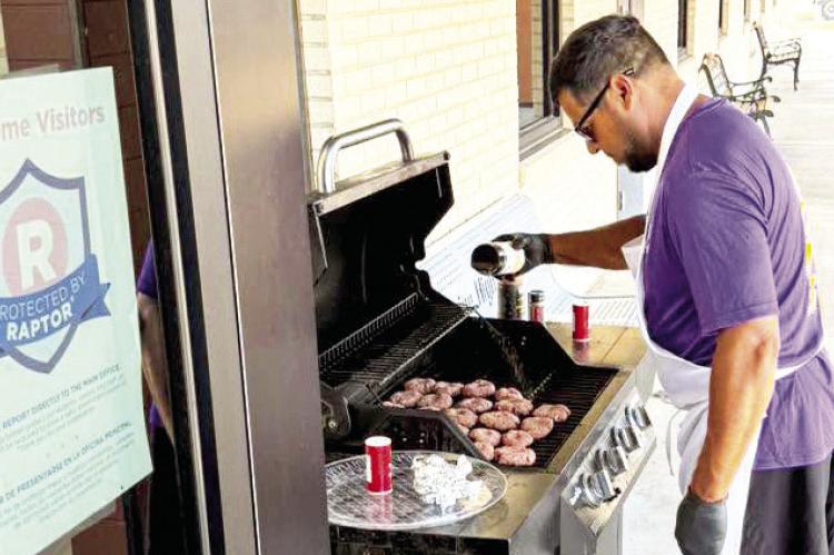 Alpine High School Coach Adam Llanez worked the grill last week during the new teacher orientation held at AHS. He grilled up sliders and hot dogs for the new additions to Alpine ISD. Courtesy photo