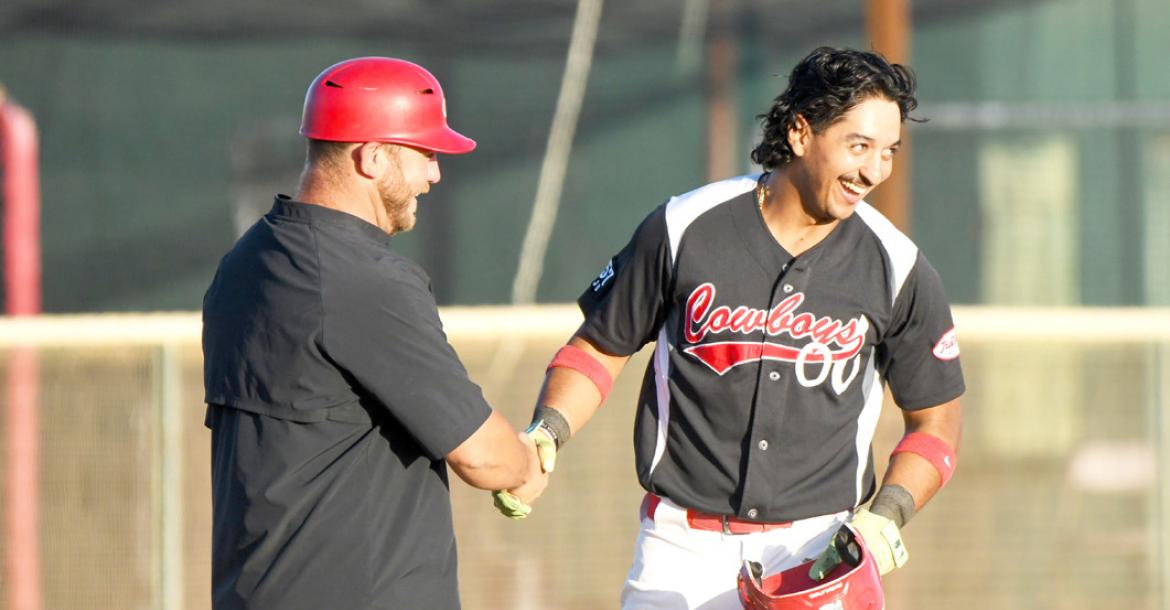 The Cowboys’Marco Martinez shakes hands with Cowboys’ manager Lance Myers in one of the team’s last battles at Kokernot Field this season. Photo by Julie Myers